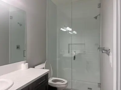 a bathroom with a toilet and a glass shower at Flowealth Property Luxury Villa Near Lake Netflix TV Wifi in Calgary