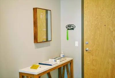 a room with a table and a mirror and a door at Bright Modern Stylish Condo in heart of Downtown (Center) in Whitehorse