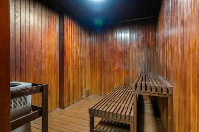 a room with a wooden wall with a bench at Downtown Near Rogers Place with Covered Parking, Sleeps 6, Pool Table, Sauna, Gym, Two Bedrooms & More in Edmonton