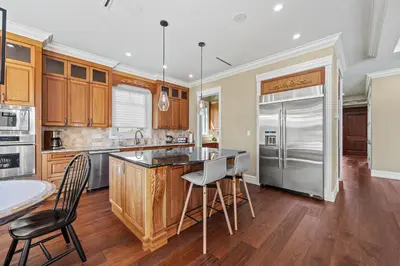 a kitchen with wooden cabinets and a stainless steel refrigerator at Spacious Cozy House in Vancouver West in Vancouver