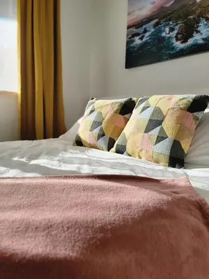 a bed with two pillows on top of it at Slack tide suite in Ucluelet