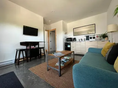 a living room with a blue couch and a table at Slack tide suite in Ucluelet