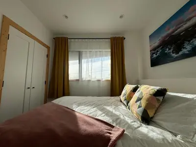 a bedroom with a bed and a window at Slack tide suite in Ucluelet