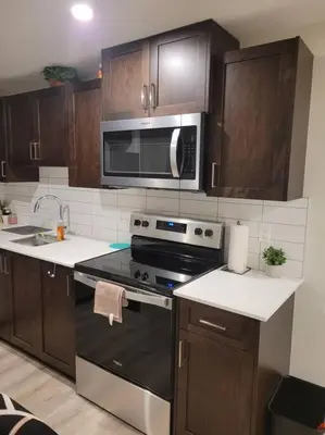 a kitchen with a stove and a microwave at Cozy brand new 2 bedroom suite in Calgary in Calgary