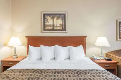 a hotel room with a bed with two lamps at Ramada by Wyndham Clairmont/Grande Prairie in Clairmont
