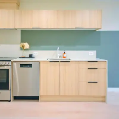 a kitchen with wooden cabinets and a sink at Newly Renovated 2 Bedroom Condo in Japantown! Near Railtown & Gastown! in Vancouver
