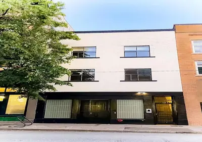 a white building with windows on a street at Newly Renovated 2 Bedroom Condo in Japantown! Near Railtown & Gastown! in Vancouver