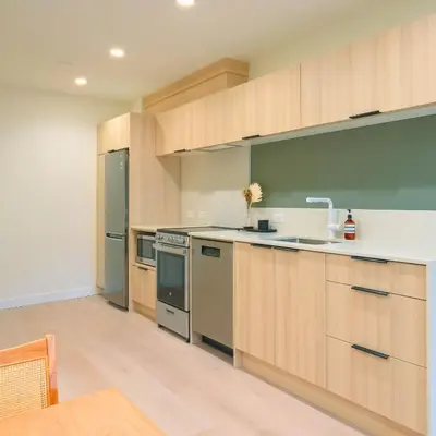 an empty kitchen with wooden cabinets and appliances at Newly Renovated 2 Bedroom Condo in Japantown! Near Railtown & Gastown! in Vancouver