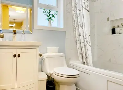 a white bathroom with a toilet and a tub and a sink at Private Guest Suite 10mins to Downtown - King Bed - Bathtub - Free Parking in Vancouver