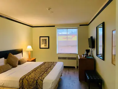 a hotel room with a bed and a window at Hotel at the Waldorf in Vancouver