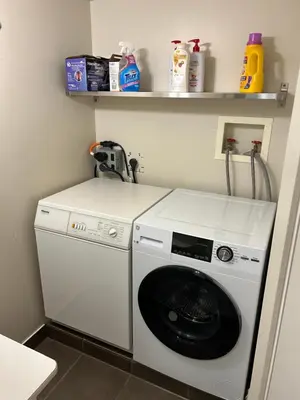 a white washer and dryer in a room at Private Bedroom, Bathroom, Shared Outdoor Pool, Hot Tub in North Vancouver
