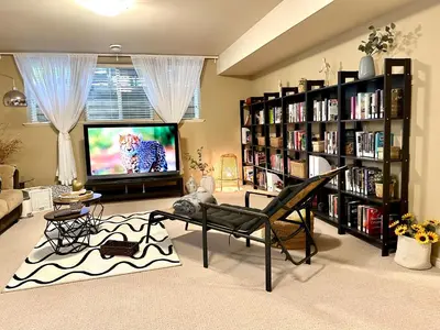 a living room with a tv and book shelves at Scorpio House Langley -ROOM A in Langley