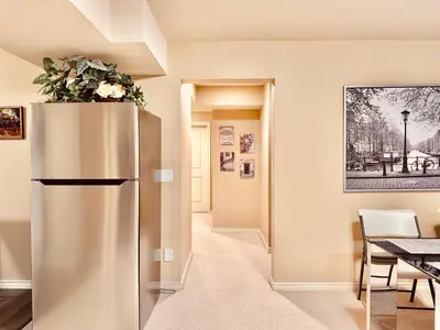 a stainless steel refrigerator in a dining room with a table at Scorpio House Langley -ROOM A in Langley
