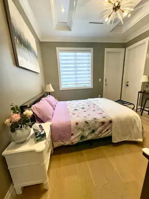 a bedroom with a bed and a table and a window at Richmond Sweet home in Richmond