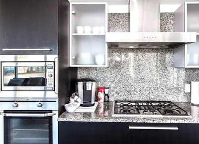 a kitchen with a stove and a microwave at Waterfalls Hotel in Downtown With Stunning Views! in Victoria