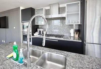a kitchen with a sink and a faucet at Waterfalls Hotel in Downtown With Stunning Views! in Victoria