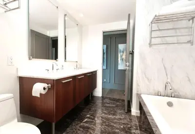 a bathroom with a sink and a toilet and a mirror at Waterfalls Hotel in Downtown With Stunning Views! in Victoria