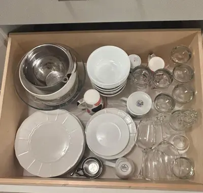 a drawer filled with white plates and dishes at Carrington Chateau in Vancouver