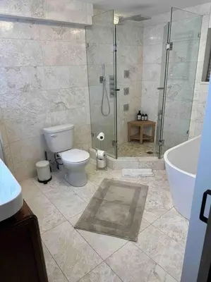 a bathroom with a shower and a toilet and a tub at Carrington Chateau in Vancouver