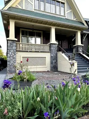 a house with a flower garden in front of it at Carrington Chateau in Vancouver