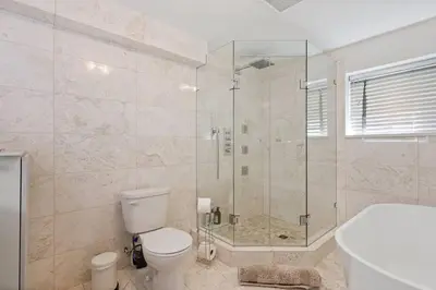a bathroom with a shower and a toilet and a tub at Carrington Chateau in Vancouver