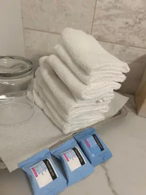 a pile of towels sitting on a bathroom counter next to a glass container at Carrington Chateau in Vancouver