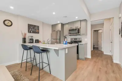 a kitchen with a counter and two bar stools at Brand New Executive Suite in Calgary