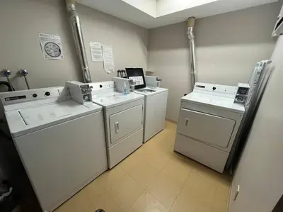 a laundry room with three washing machines at Snow Creek Lodge by StayIn in Fernie