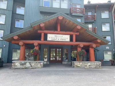 a large building with a sign in front of it at Snow Creek Lodge by StayIn in Fernie