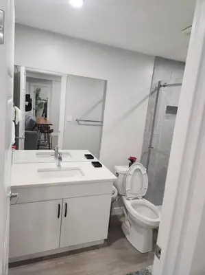 a white bathroom with a toilet and a sink at Cozy basement for a lovely stay & perfect for WFH in Edmonton
