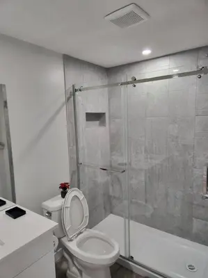 a bathroom with a toilet and a glass shower at Cozy basement for a lovely stay & perfect for WFH in Edmonton