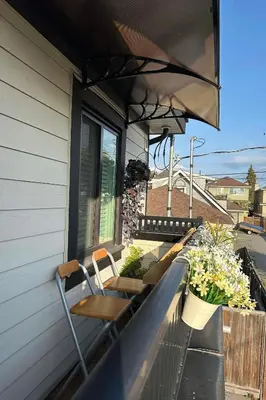 a balcony with chairs and plants on a house at 2BR 1.5BA Full Kitchen Private Guest House - Free Parking - Central Location in Vancouver