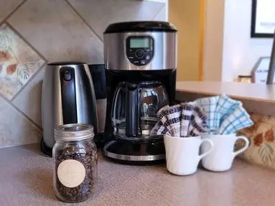 a coffee maker sitting on a counter next to cups at Pine Cone Cabin by StayIn in Radium Hot Springs