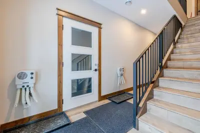 a hallway with stairs and a door with a window at 22 Sunniva by StayIn in Fernie