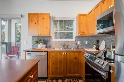 a kitchen with wooden cabinets and a sink and a stove at Desirable Blueberry Hill in Whistler
