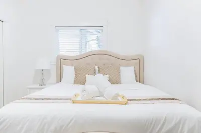 a white bed with two towels on top of it at Si & Daniel Home Near YVR Airport & Skytrain Separate Entry Free Parking in Richmond