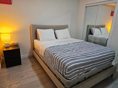 a bedroom with a large bed with a mirror at New built house, Stay in Style Guest Suite, 2bedroom, 2bed, 2bath in Edmonton
