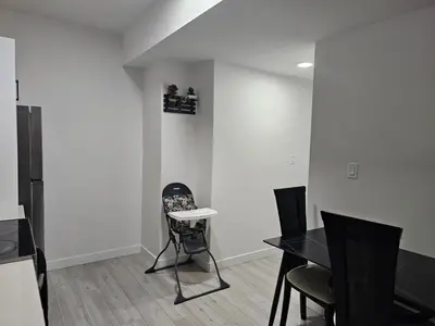 a dining room with white walls and a table and chairs at New built house, Stay in Style Guest Suite, 2bedroom, 2bed, 2bath in Edmonton