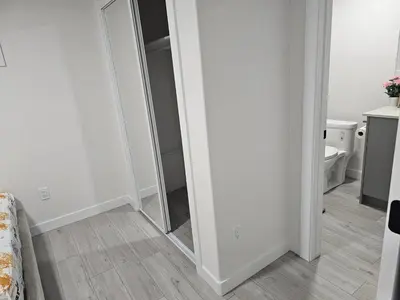 a hallway with a mirror in a white room at New built house, Stay in Style Guest Suite, 2bedroom, 2bed, 2bath in Edmonton