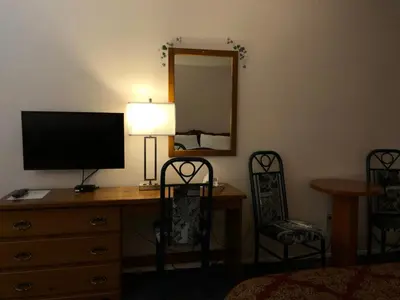 a bedroom with a desk with a television and a mirror at Chase Country Inn in Chase