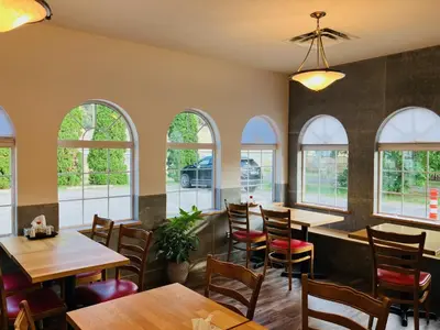 a restaurant with tables and chairs and windows at Chase Country Inn in Chase