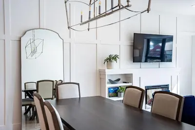 a dining room with a table and chairs and a tv at Stoked 4Ever - Revelstoke Condo (+Hot Tub) in Revelstoke