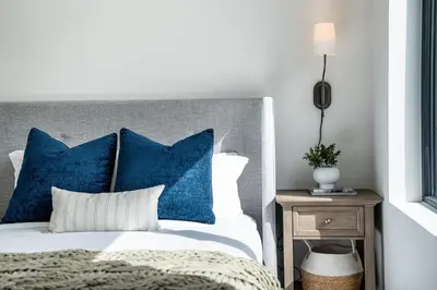 a bedroom with a bed with blue pillows at Stoked 4Ever - Revelstoke Condo (+Hot Tub) in Revelstoke