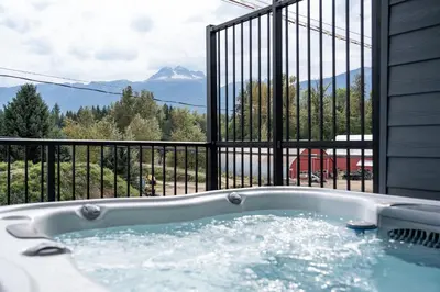a jacuzzi tub with a view of a mountain at Stoked 4Ever - Revelstoke Condo (+Hot Tub) in Revelstoke