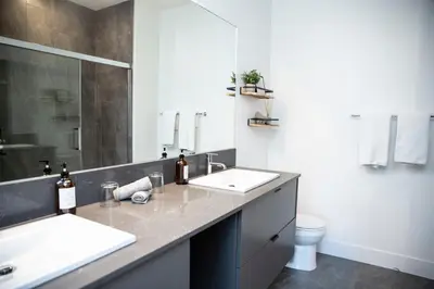 a bathroom with two sinks and a toilet at Selkirk Powder Dream - Cozy Condo (+Hot Tub) in Revelstoke