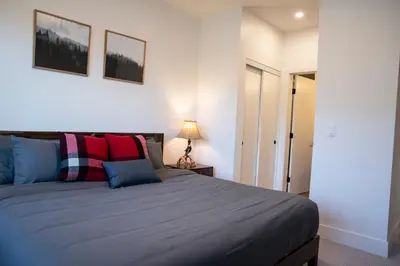 a bedroom with a large bed and a lamp at Selkirk Powder Dream - Cozy Condo (+Hot Tub) in Revelstoke