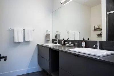 a bathroom with two sinks and a large mirror at Selkirk Powder Dream - Cozy Condo (+Hot Tub) in Revelstoke
