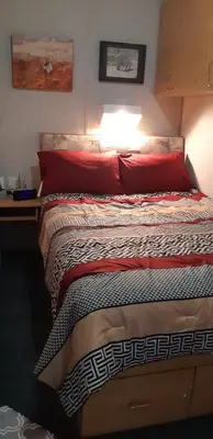 a bedroom with a bed with red pillows and avertisement at Peace and Quiet in Lac La Biche