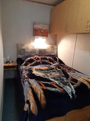 a bedroom with a bed with a blanket on it at Peace and Quiet in Lac La Biche