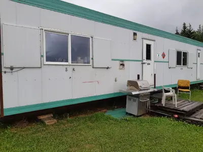 a large white house with a desk and a window at Peace and Quiet in Lac La Biche
